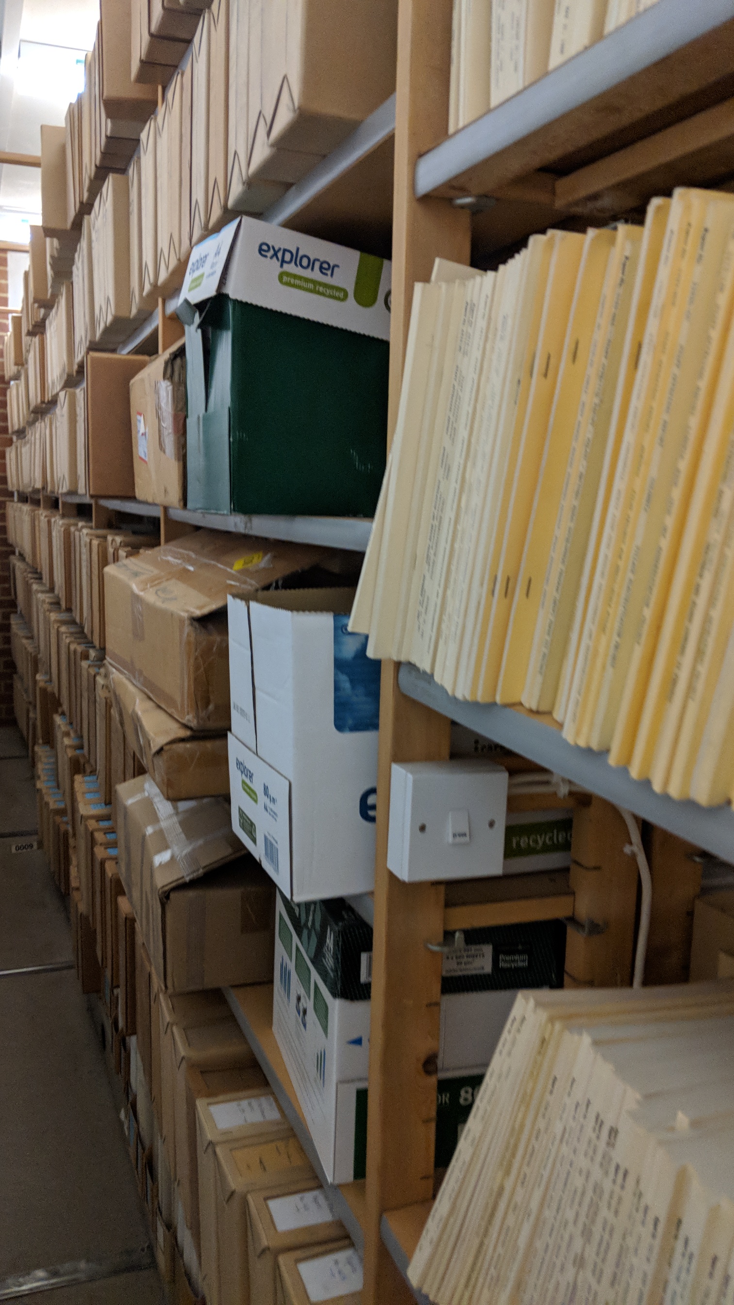 Row of wooden shelving full of old pamphlet boxes and pamphlets